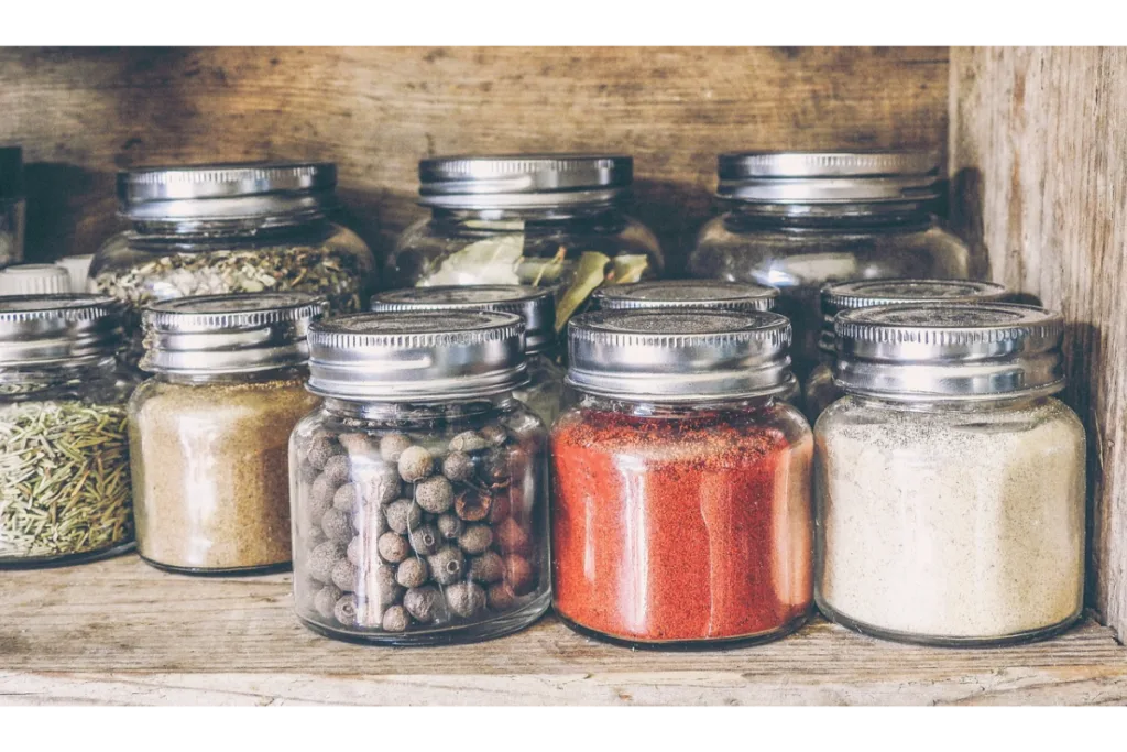 Different types of spices in glass jars.