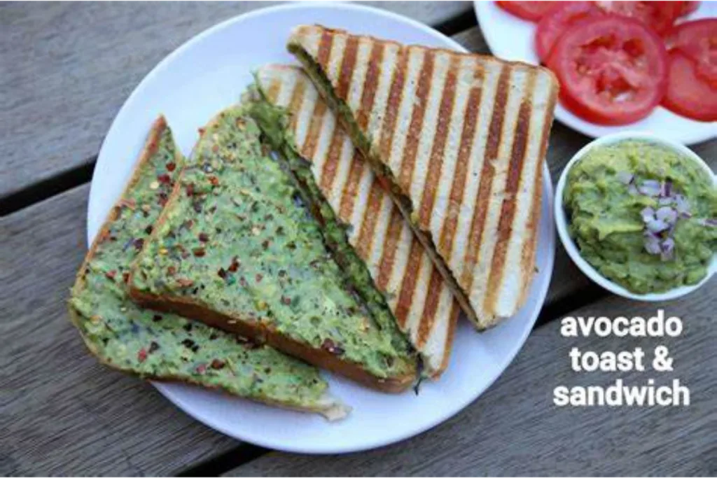 Assembled avocado toast on a white plate and placed on a wooden bench.