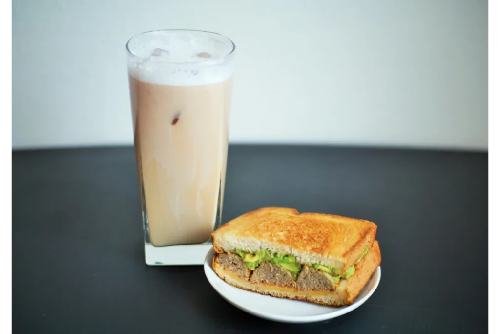 With a white & grey background, a glass of milk, and an avocado toast in a white place - avocado toast recipe